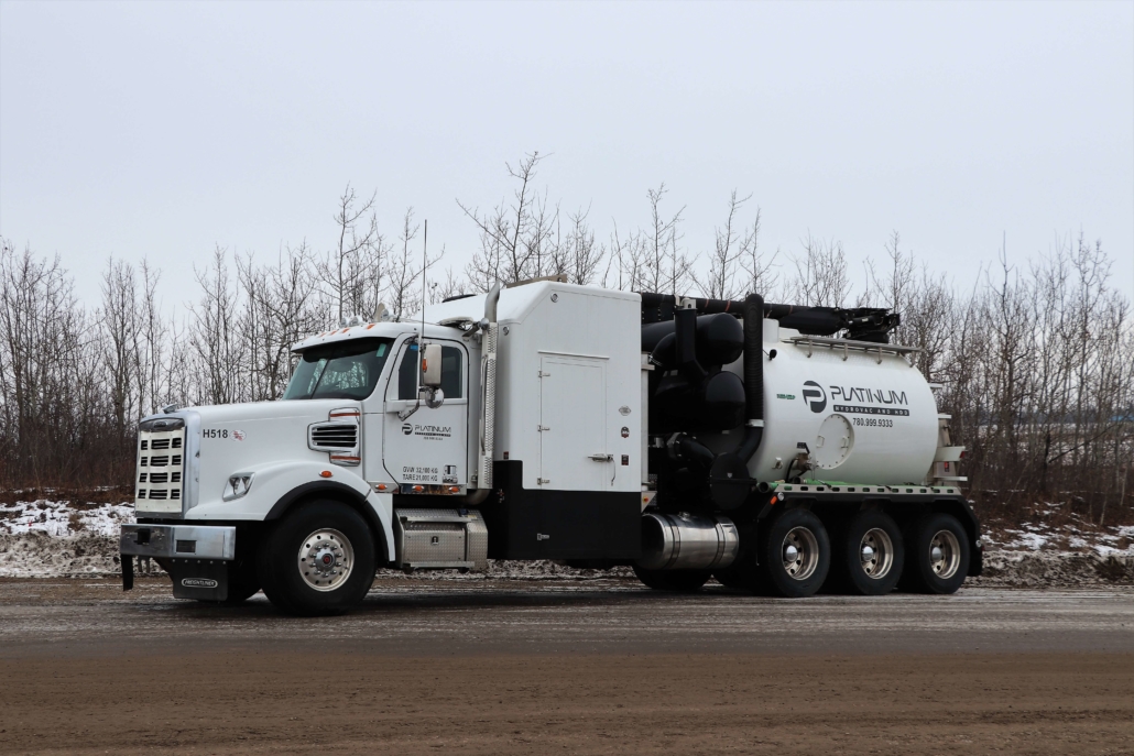 A white platinum hydrovac truck parked on the road