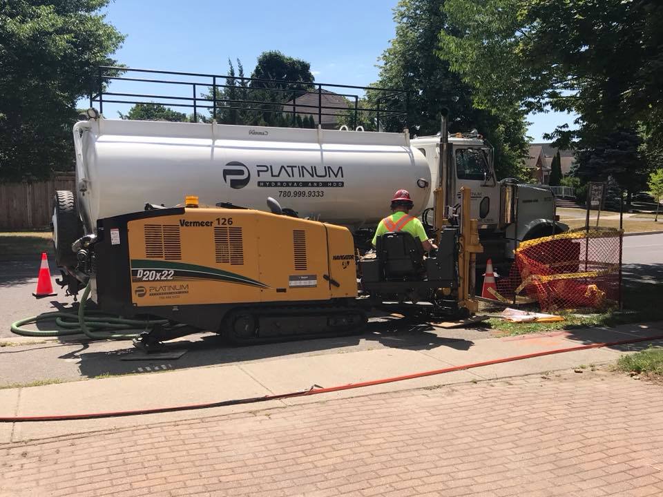 A platinum horizontal directional driller drilling into a residential street