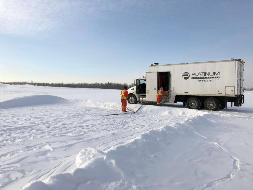 Platinum employee Lorne A and two other Platinum employees using a steamtruck to help make a skating rink for the locals